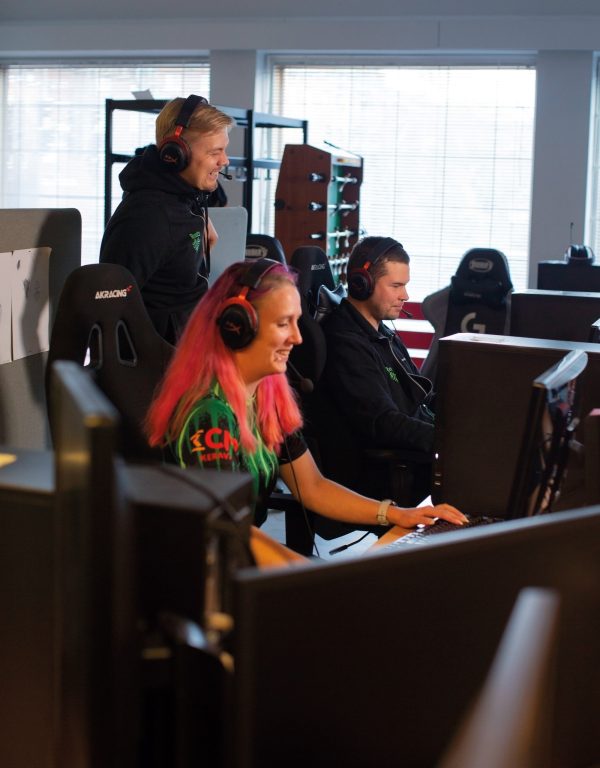Roots Gaming ry:n Sonja Ahtiainen, Jyri Kunttu ja Janne Vuorensyrjä pelaamassa Roots Gaming ry:n tiloissa